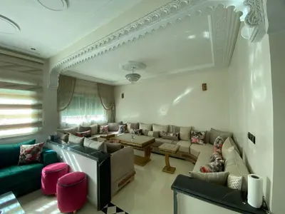 a living room with couches and a table at Family Apartment in City Centre in Douar Oulad Mhammed