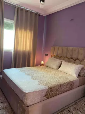 a bedroom with a large bed with purple walls at Family Apartment in City Centre in Douar Oulad Mhammed