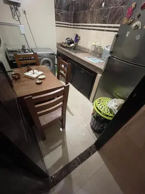 a kitchen with a table and a refrigerator at Rayhana in Oulad Akkou