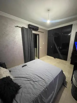 a bedroom with a bed and a tv on the wall at Rayhana in Oulad Akkou