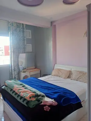 a bedroom with a bed with a blue blanket on it at Kinan in Taza