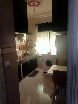 a kitchen with a refrigerator and a washing machine at Kinan in Taza