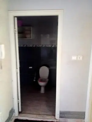 a bathroom with a toilet in a dark room at Kinan in Taza