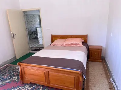 a bedroom with a wooden bed with a mirror at Halouli in Tinerhir