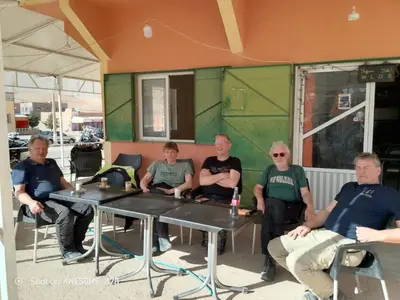 a group of men sitting at tables in front of a building at Rani hani chez ali in Tinerhir