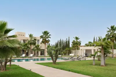 a resort with a swimming pool and palm trees at Marilah in Marrakech