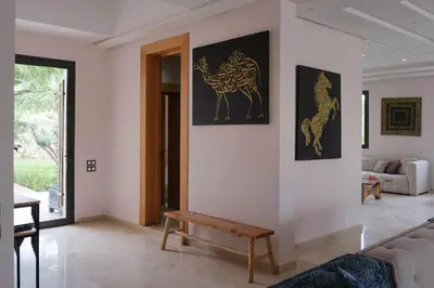 a living room with a couch and paintings on the wall at Marilah in Marrakech