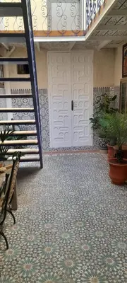a room with a white door and a floor at Riad Kouira in Oulad Akkou