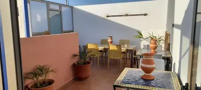 a balcony with a table and chairs on it at Riad Kouira in Oulad Akkou