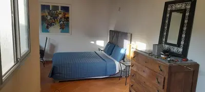 a bedroom with a bed and a dresser and a mirror at Riad Kouira in Oulad Akkou