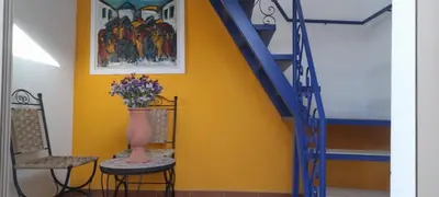 a staircase with a vase of flowers on a table and two chairs at Riad Kouira in Oulad Akkou