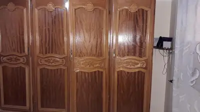 a wooden cabinet with two doors in a room at Chez Faouzia in Taza