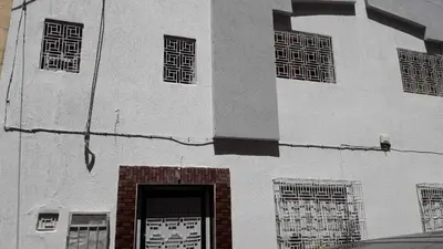 a large white building with windows and a door at Chez Faouzia in Taza
