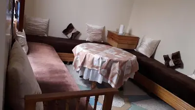 a living room with four beds and a table at Chez Faouzia in Taza