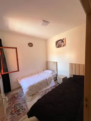 a bedroom with two beds and a mirror at Smartkeys in Oulad Akkou