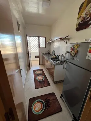 a kitchen with a refrigerator and some rugs on the floor at Smartkeys in Oulad Akkou