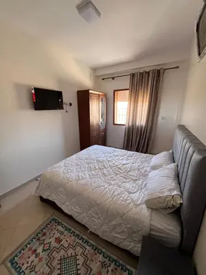 a bedroom with a bed and a couch at Smartkeys in Oulad Akkou