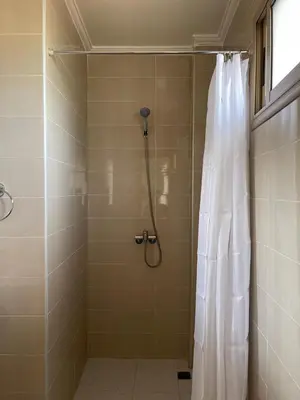 a shower with a white shower curtain in a bathroom at Dyafat Abla in Oulad Akkou