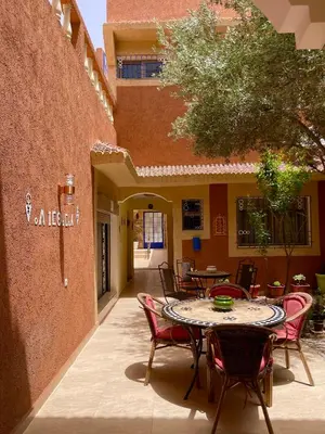 a patio with a table and chairs in a courtyard at Dyafat Abla in Oulad Akkou