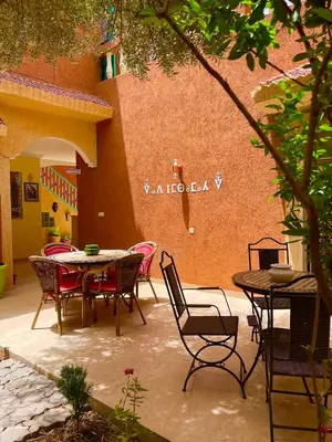a patio with a table and chairs and a building at Dyafat Abla in Oulad Akkou