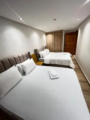 a hotel room with two beds and a couch at Dar élégance in Oulad Akkou