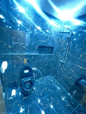 a blue tiled bathroom with a toilet and a shower at Dar élégance in Oulad Akkou