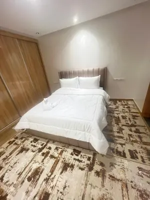 a bedroom with a large white bed and a rug at Dar élégance in Oulad Akkou