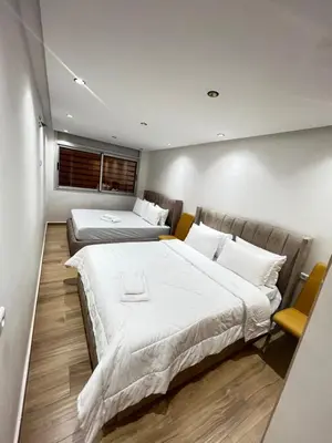 a bedroom with two beds and a window at Dar élégance in Oulad Akkou