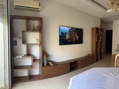 a bedroom with a bed and a painting on the wall at Appartement avec piscine in Oulad Akkou