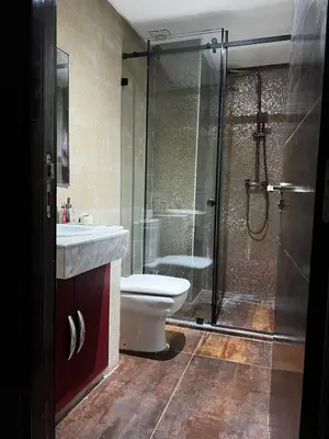 a bathroom with a shower and a toilet and a sink at Appartement avec piscine in Oulad Akkou