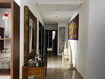 a hallway with a mirror and a table in a room at Appartement avec piscine in Oulad Akkou