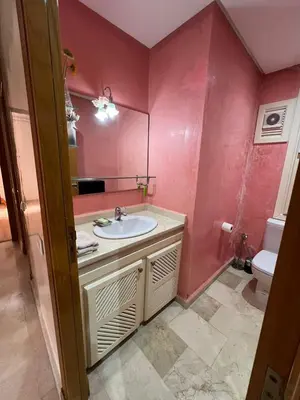 a bathroom with a sink and a mirror and a toilet at appartement amine in Oulad Akkou