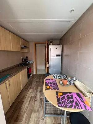 a small kitchen with a table and a refrigerator at appartement amine in Oulad Akkou