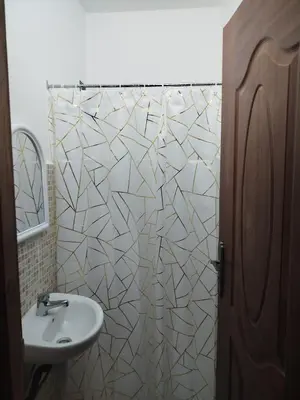 a bathroom with a sink and a white shower curtain at MBS imo in Oulad Akkou