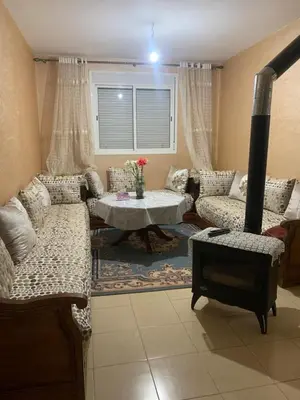 a living room with couches and a table and a fireplace at Les jardins d'Ifrane in Ifrane