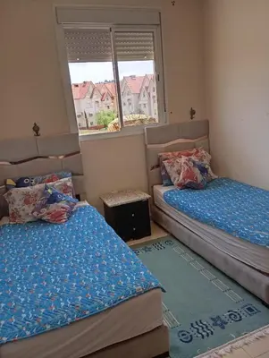 a bedroom with two beds and a window at حدائق افران in Oulad Akkou