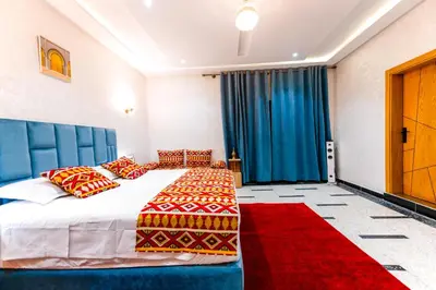 a bedroom with a large bed and a red rug at Riad Les Champs De Fès in Fès