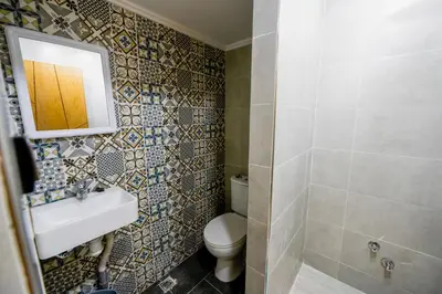 a bathroom with a toilet and a sink and a mirror at Riad Les Champs De Fès in Fès