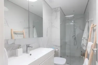 a white bathroom with a sink and a shower at Refined studio with sea view in Oulad Akkou