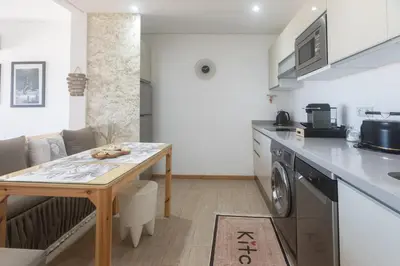 a kitchen and living room with a table and a washing machine at Refined studio with sea view in Oulad Akkou