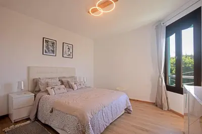a white bedroom with a bed and a large window at Refined studio with sea view in Oulad Akkou