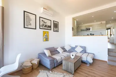 a living room with a blue couch and a table at Refined studio with sea view in Oulad Akkou