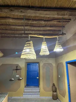 a room with a blue door and three lights at Auberge Lwalida in Ouled Sguir