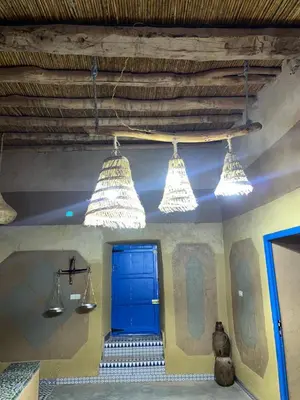 a room with a blue door and three lights at Auberge Lwalida in Ouled Sguir