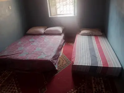 two twin beds in a room with a window at Gite d'étape La terre Amazigh in Oulad Akkou