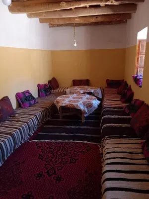 a room with four beds and a couch in it at Gite d'étape La terre Amazigh in Oulad Akkou