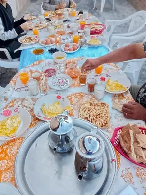 a long table with plates of food on it at Gite d'étape La terre Amazigh in Oulad Akkou