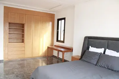 a bedroom with a bed and a desk next to a window at Villa Bakhta in Najem