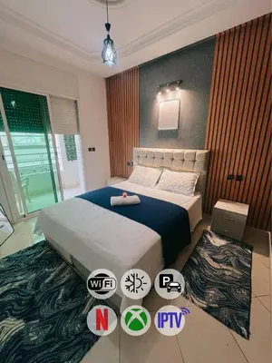 a bedroom with a king sized bed in a room at Perfect Cozy Apartment in City Center Hamrya in Meknès