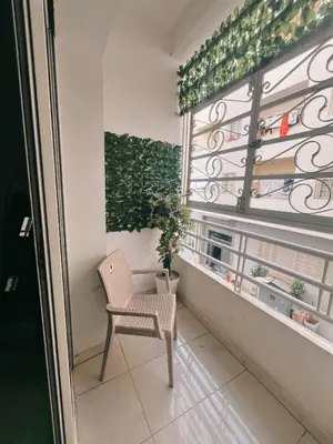 a chair in front of a window with a plant at Perfect Cozy Apartment in City Center Hamrya in Meknès